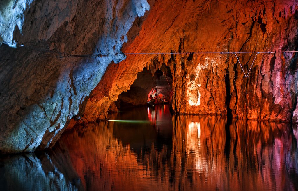Interno delle Grotte di Pertosa-Auletta con il fiume sotterraneo navigabile e le suggestive formazioni calcaree illuminate.